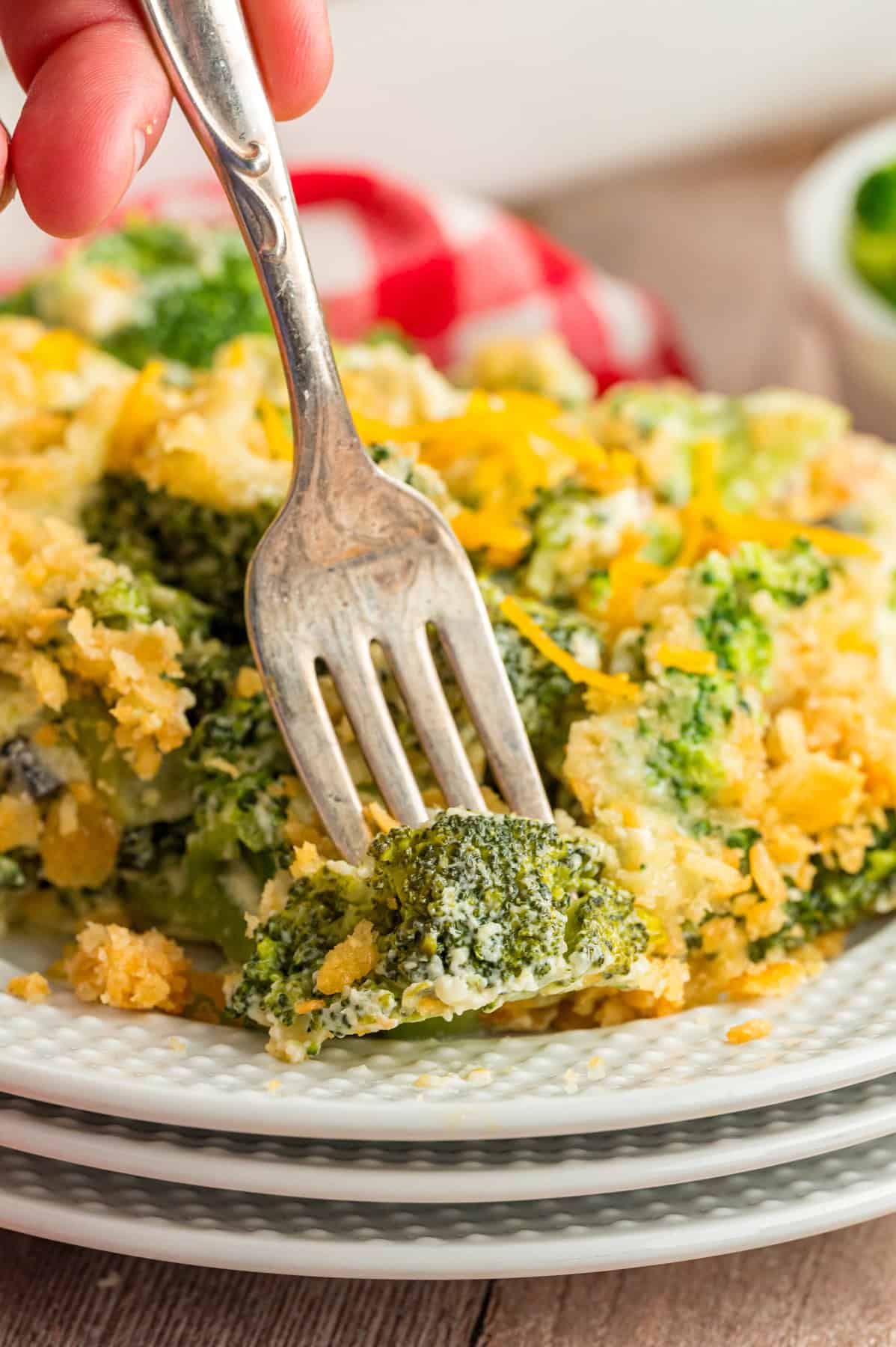 A fork in a piece of broccoli cheese casserole