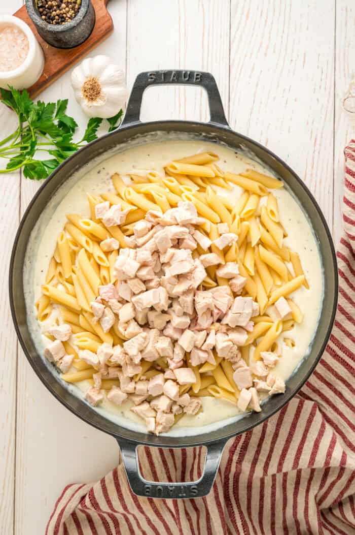 Noodles and chicken added to alfredo sauce