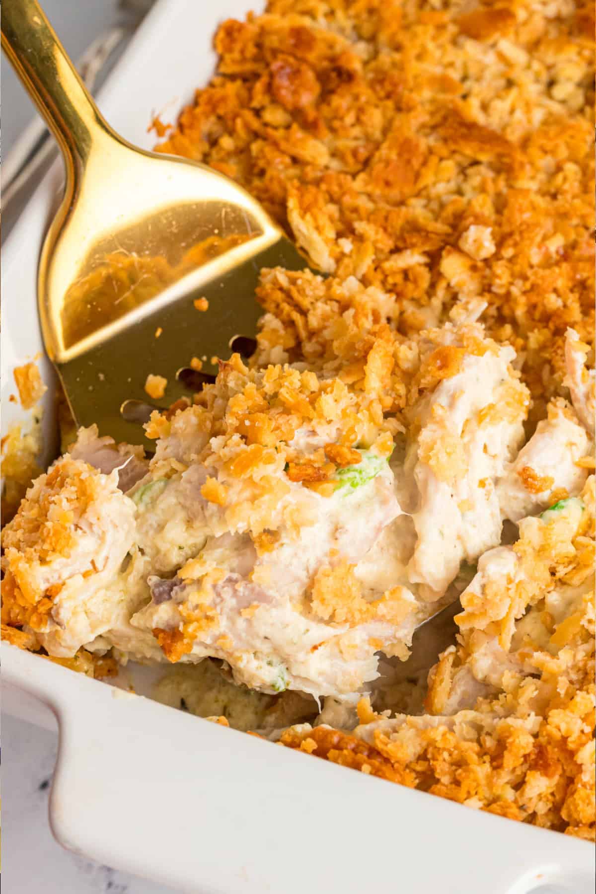 A creamy chicken mixture is topped with buttery Ritz crackers in this easy Ritz Chicken Casserole recipe. 7 ingredients & 15 minutes of prep! Ritz Chicken Casserole in a pan with a spatula