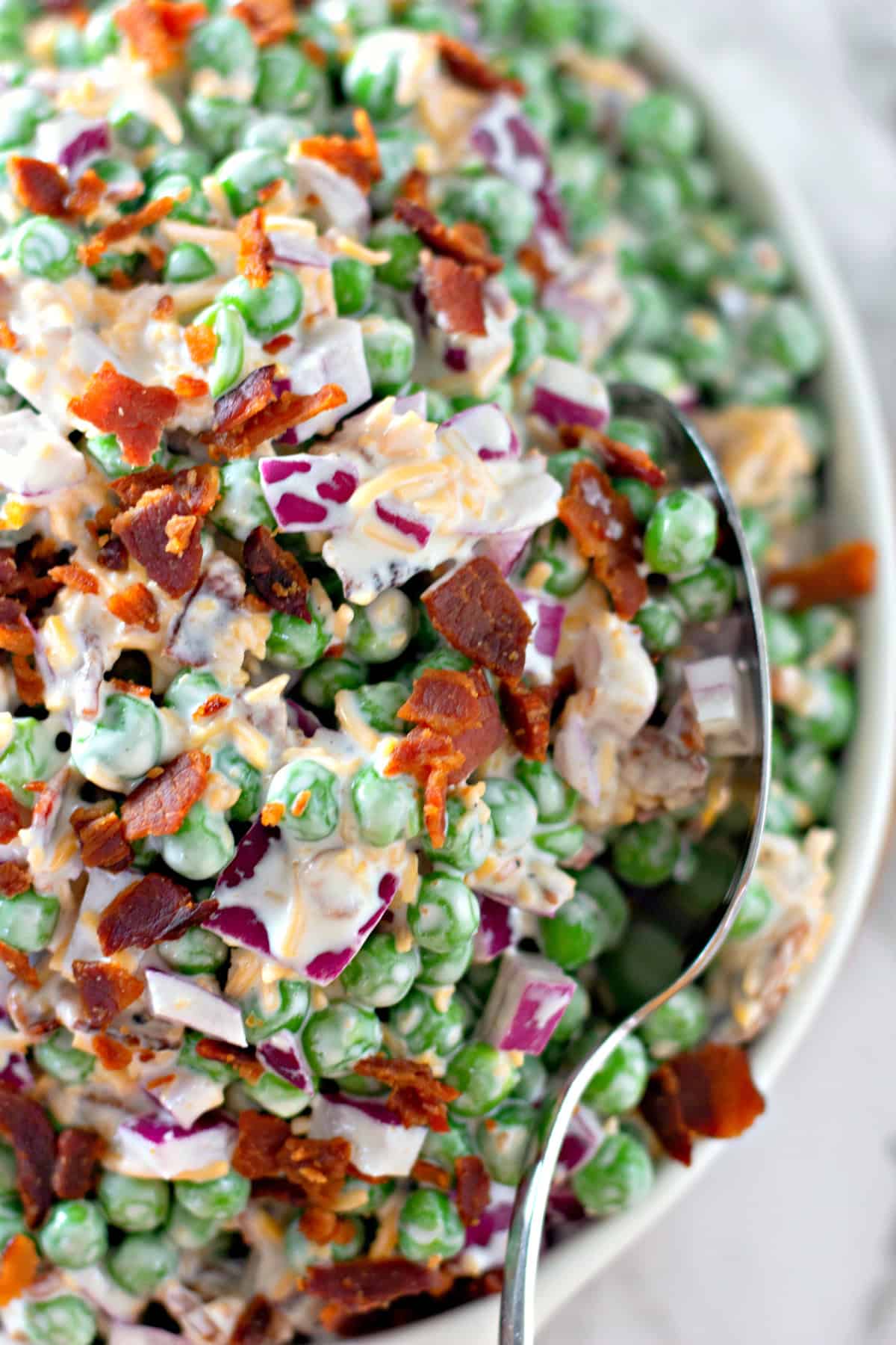bowl of pea salad with serving spoon