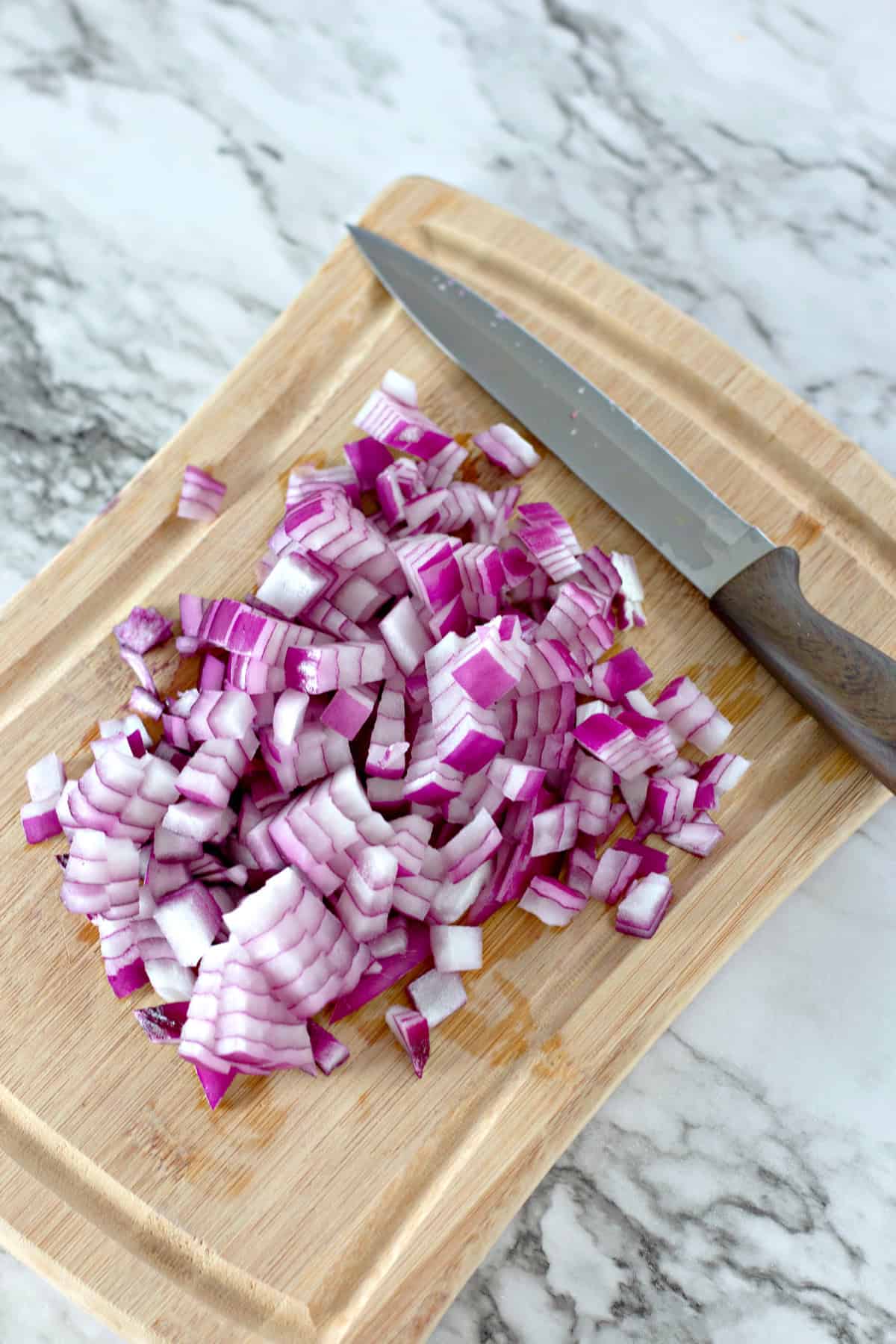 red onions cut on wooden board with knife