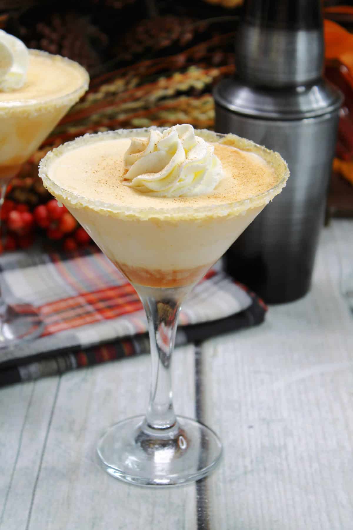 This Pumpkin Martini is made with pumpkin spiced Baileys, caramel flavored liquor and heavy cream creating the perfect Fall cocktail! Pumpkin Martini with whip cream on top