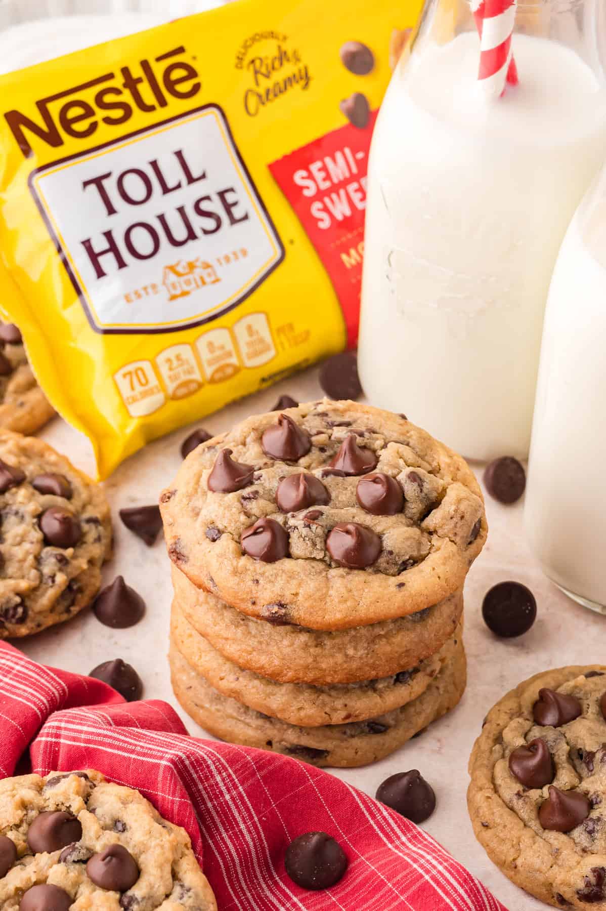 A stack of Toll House chocolate chip cookies in front of a bag of chocolate chips