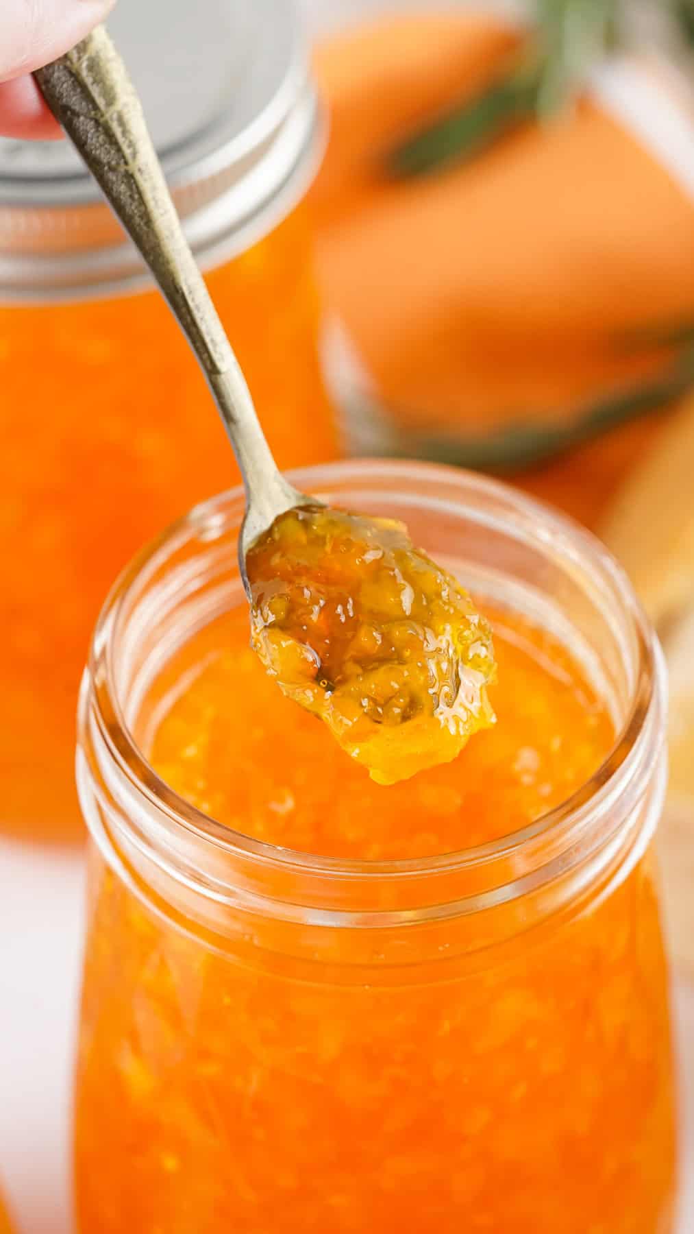 With only 5 ingredients, this Orange Marmalade recipe is super easy and perfect for the citrus lover. Great on toast, biscuits, and more! A spoon of orange marmalade above the jar