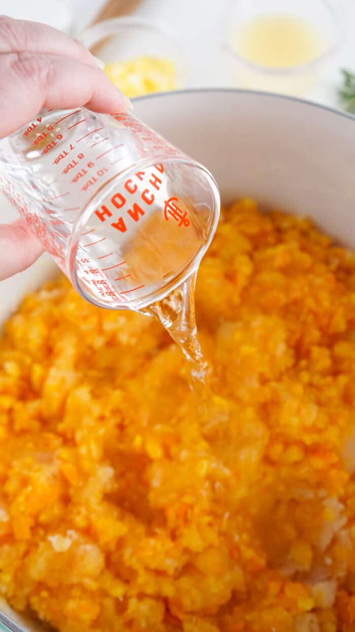Adding water to a pot of chopped oranges