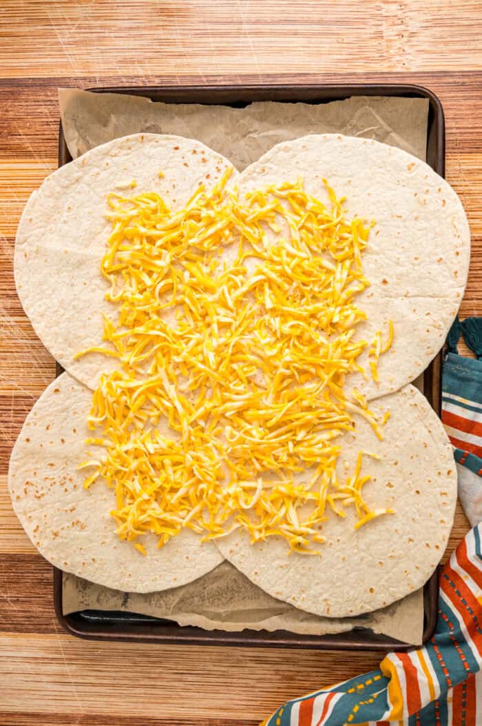 Shredded cheese spread on tortillas