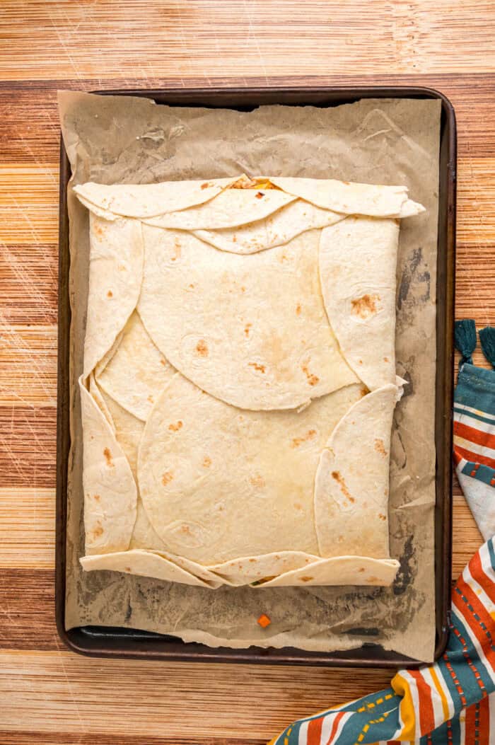 An unbaked sheet pan quesadilla on a sheet pan