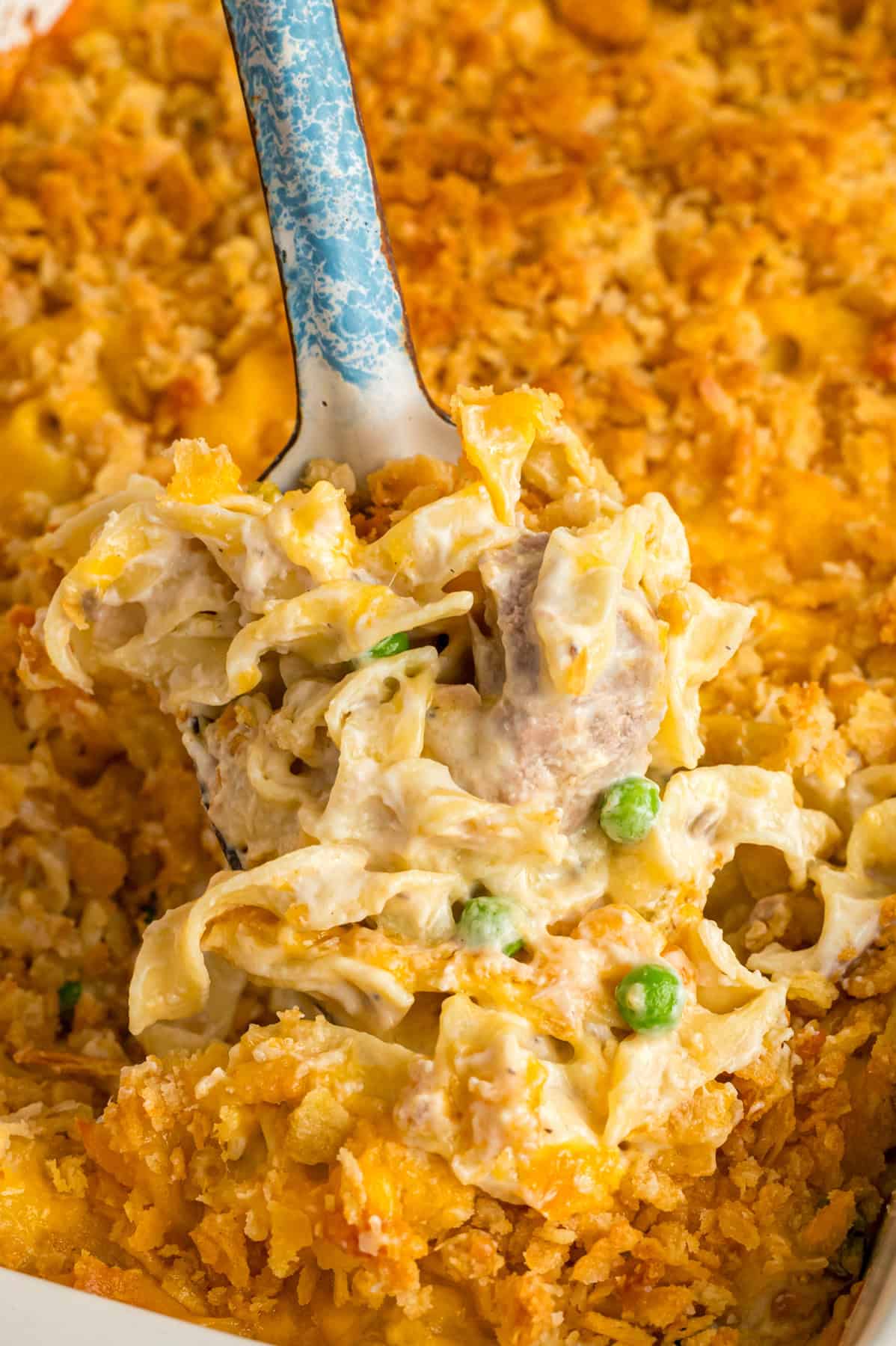Canned tuna, egg noodles, cream of mushroom soup, and cheddar cheese combine to make this easy Tuna Noodle Casserole. A serving spoon of tuna noodle casserole