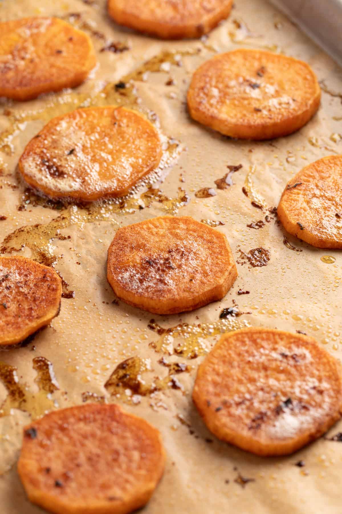 These simple Roasted Sweet Potatoes are a flavorful and versatile side dish that pairs perfectly with any meal. They’re caramelized on the outside, tender on the inside, and naturally sweet and buttery—my favorite way to enjoy sweet potatoes! Roasted sweet potato slices fresh out of the oven, with crispy edges and caramelized tops.