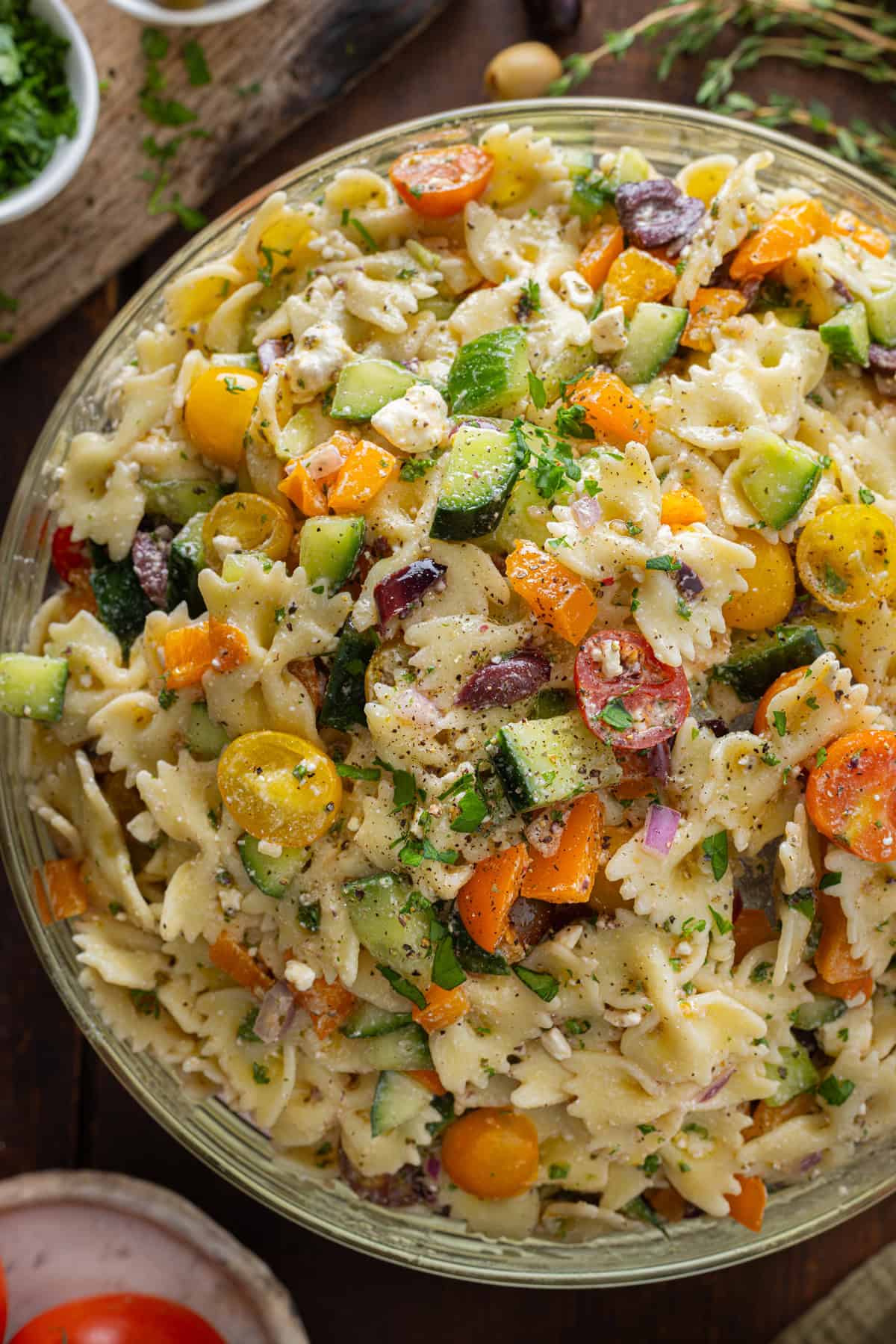 This Greek Pasta Salad is loaded with fresh veggies, Kalamata olives, and feta cheese, then tossed in a light but tangy vinaigrette. Overhead view of a big bowl of Greek pasta salad