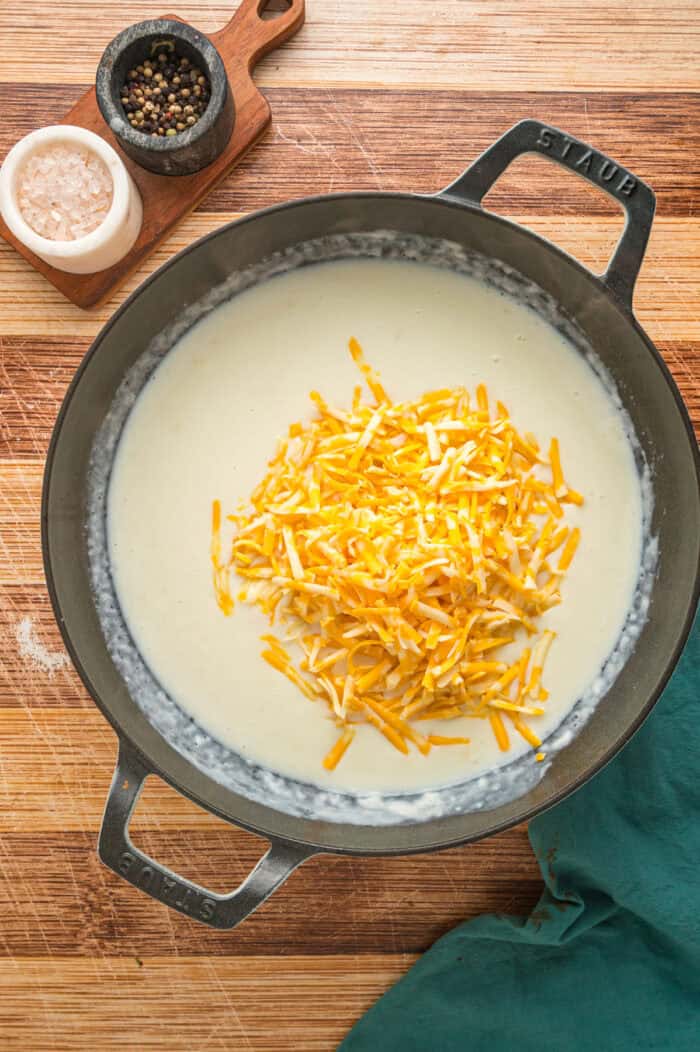 Shredded cheese added to a cream sauce