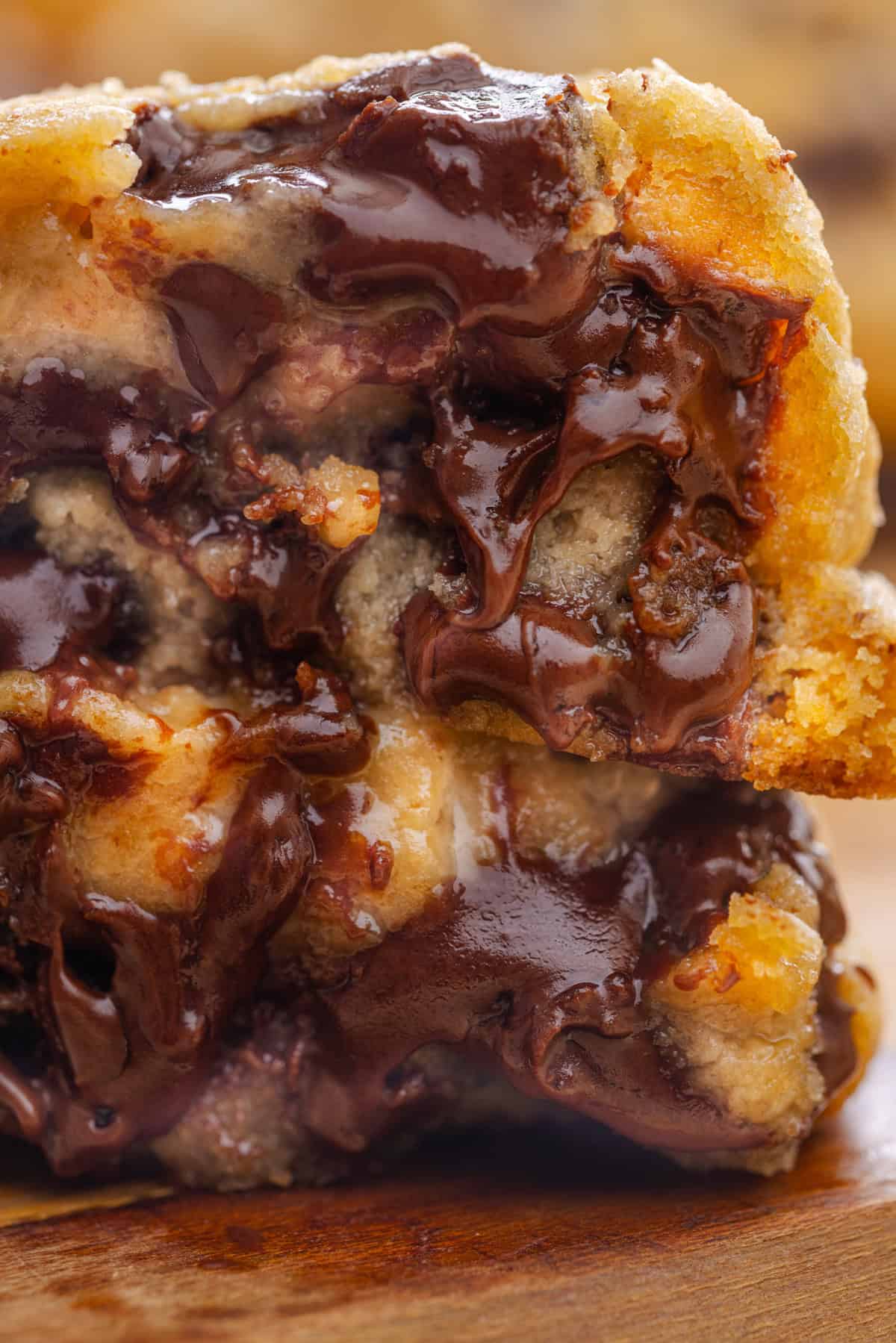 Close up of two halves of a gooey chocolate chip cookie to show the inside
