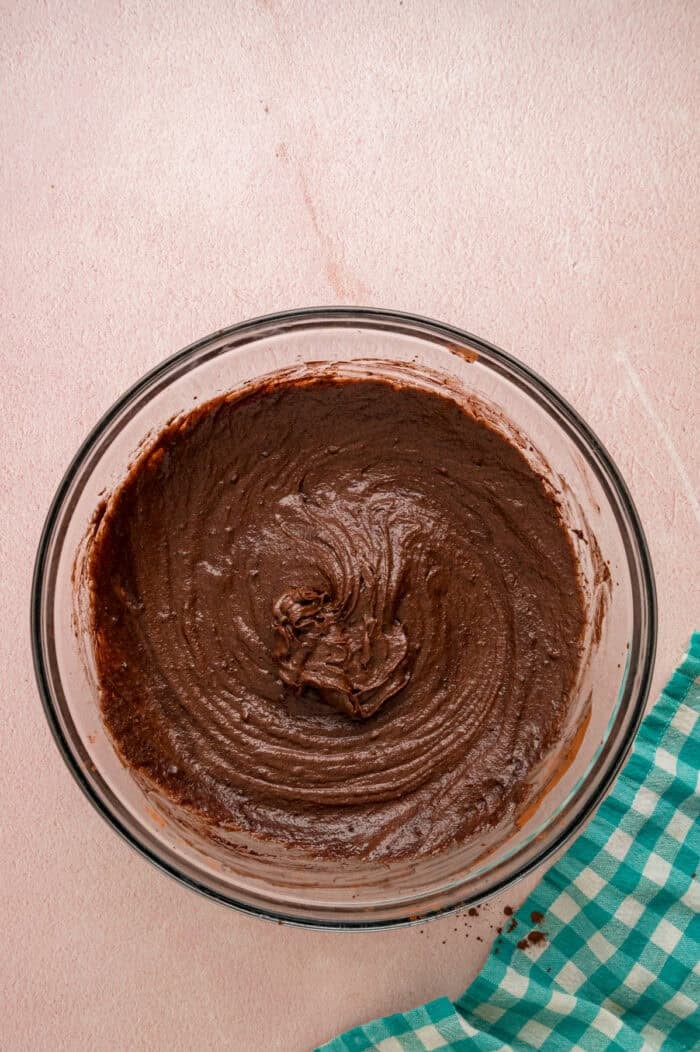 With dense, chewy brownies topped with frosting and rainbow candy-coated chocolate chips, these Cosmic Brownies are a nostalgic treat. Chocolate brownie batter in a bowl