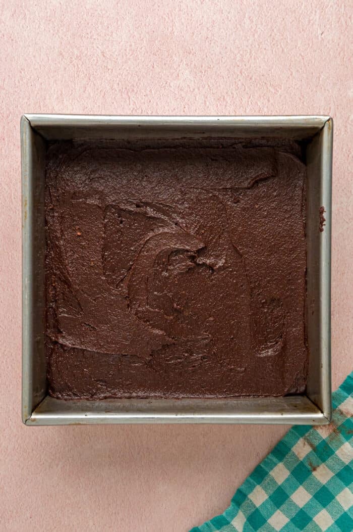 With dense, chewy brownies topped with frosting and rainbow candy-coated chocolate chips, these Cosmic Brownies are a nostalgic treat. Brownie batter in a square pan
