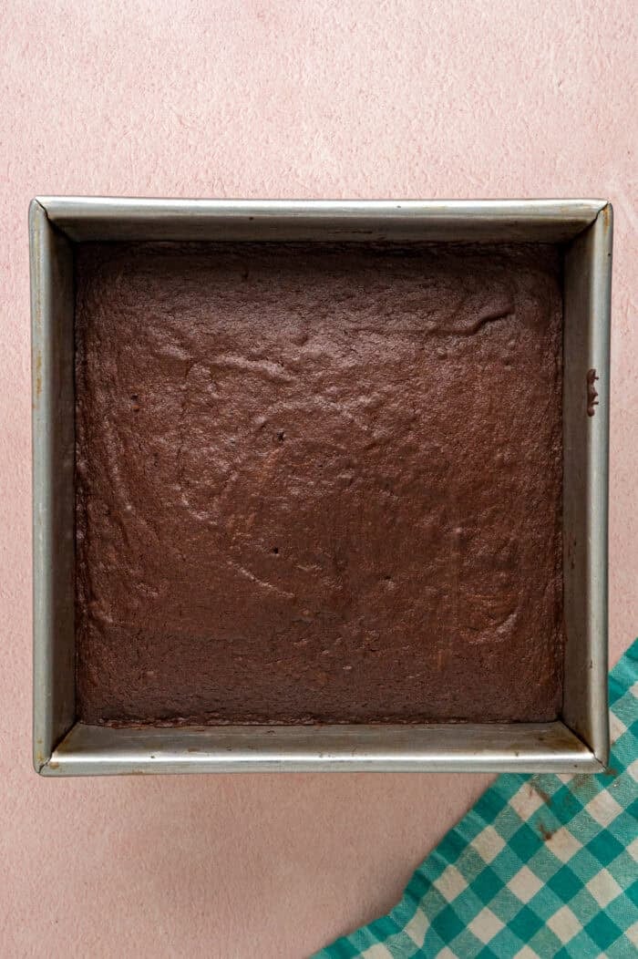 With dense, chewy brownies topped with frosting and rainbow candy-coated chocolate chips, these Cosmic Brownies are a nostalgic treat. Baked brownies in a square pan