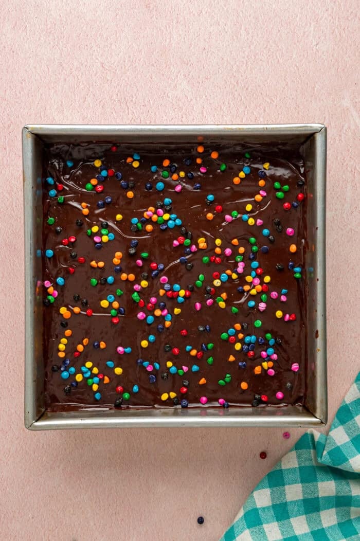With dense, chewy brownies topped with frosting and rainbow candy-coated chocolate chips, these Cosmic Brownies are a nostalgic treat. Cosmic brownies in a square pan