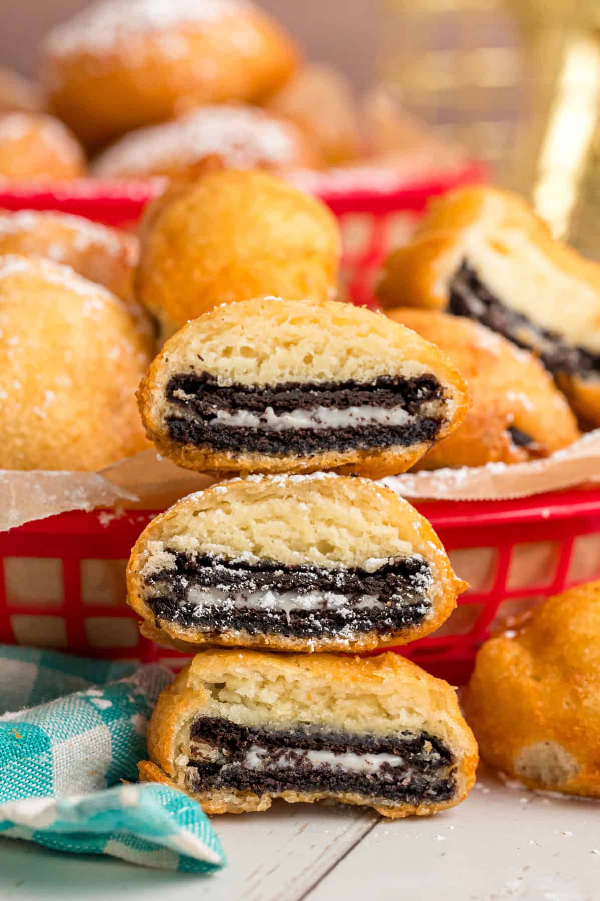 With Oreos coated in pancake batter and fried to golden perfection, this Deep Fried Oreos recipe turns fair food into an anytime treat. Three halves of deep fried Oreos stacked in front of a basket of them