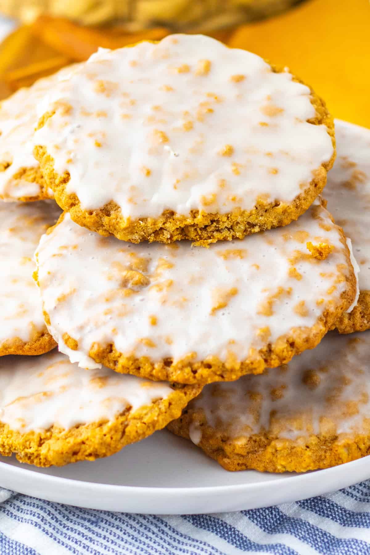 Soft oatmeal cookies are topped with a simple vanilla icing in these Iced Oatmeal Cookies. Better than any you can buy at the store! Iced Oatmeal Cookies stacked on a plate