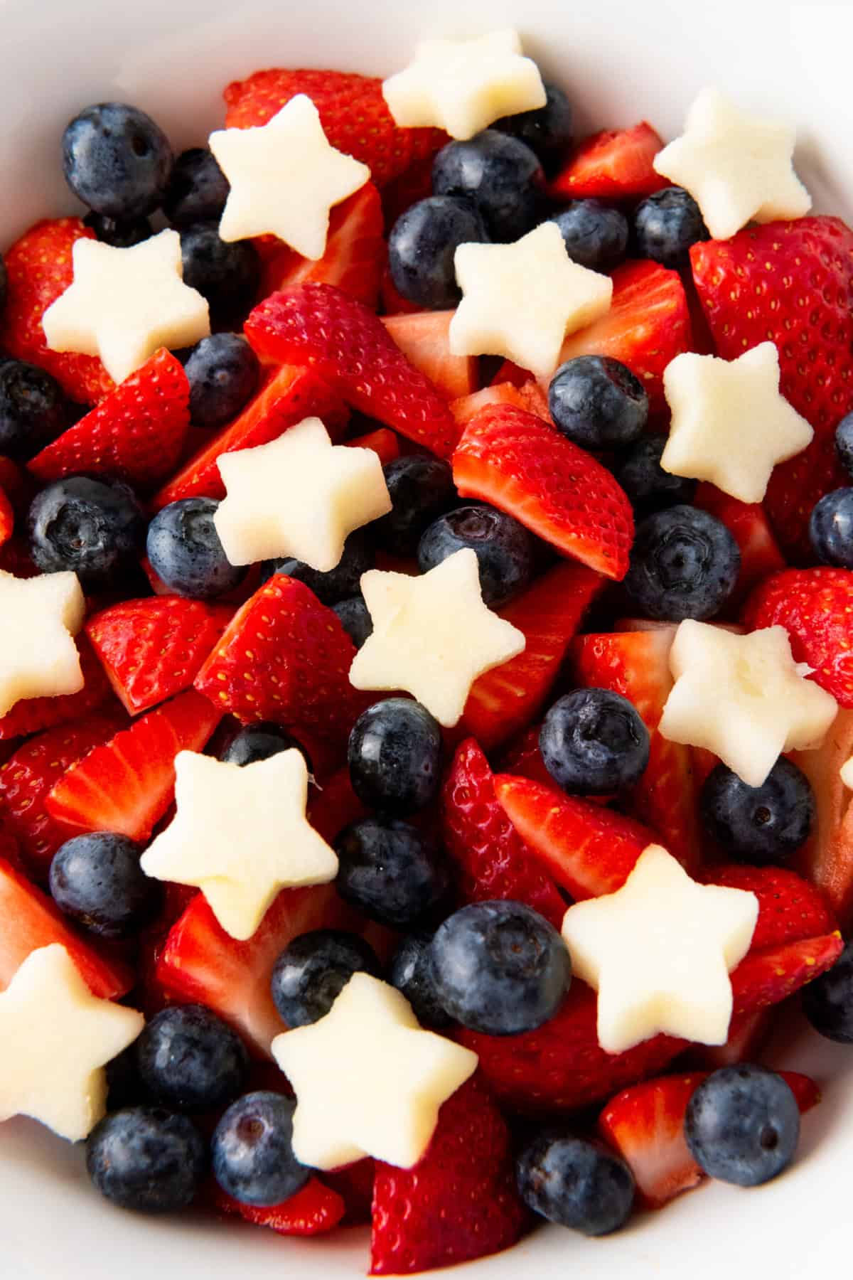 This 4th of July Fruit Salad is so festive and easy to make! It's perfect for Memorial Day, 4th of July or any patriotic gathering. 4th of July Fruit Salad in a bowl