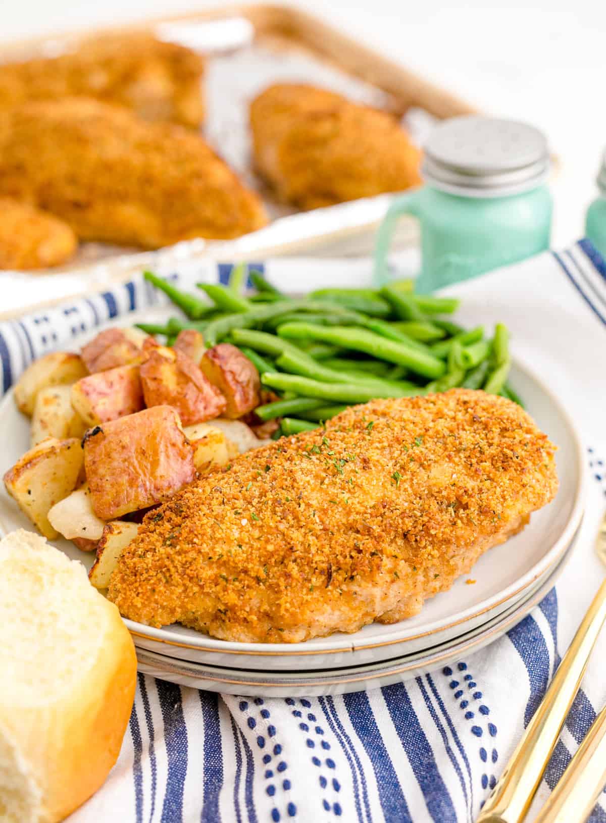 A plate of shake and bake chicken with green beans and potatoes
