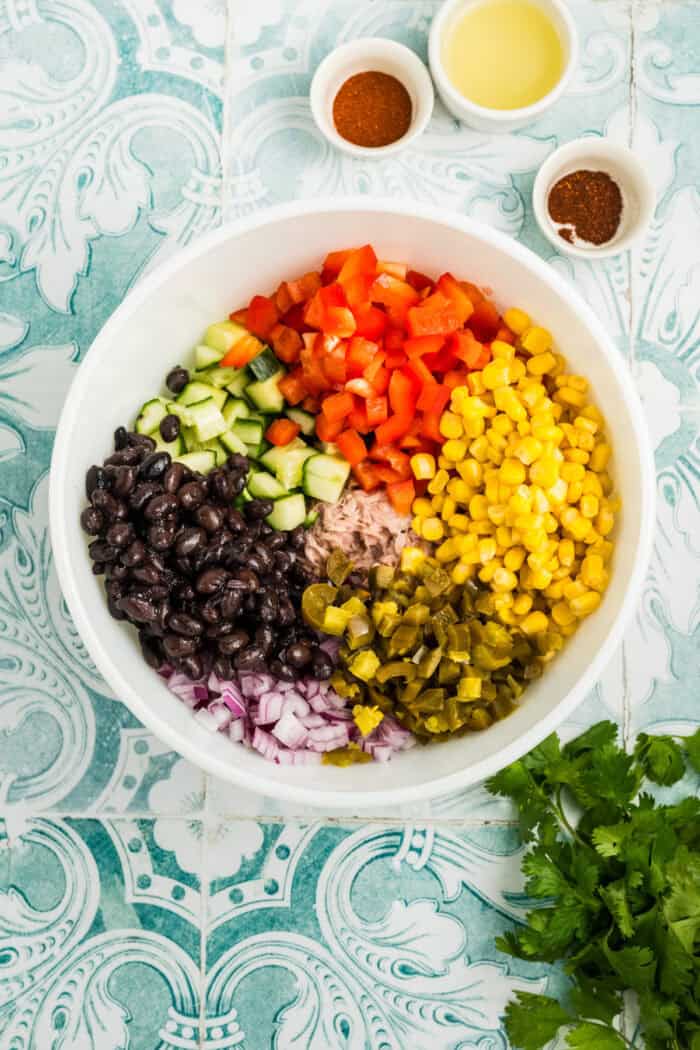 Corn, bell peppers, jalapenos, black beans, onion, and cucumber in a bowl