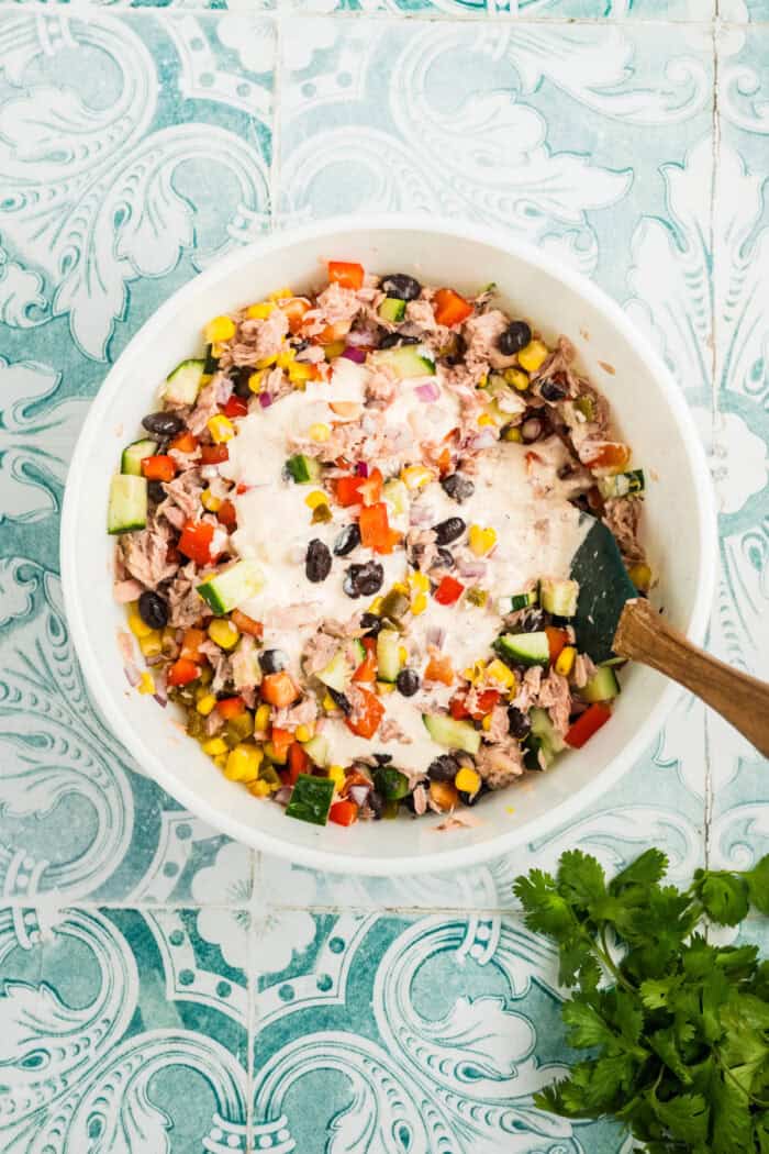 Stirring the dressing into the salad ingredients