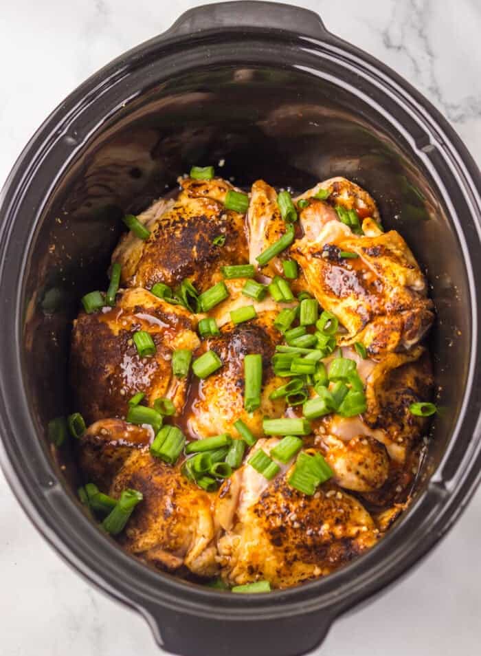 Overhead view of a slow cooker with jerk chicken