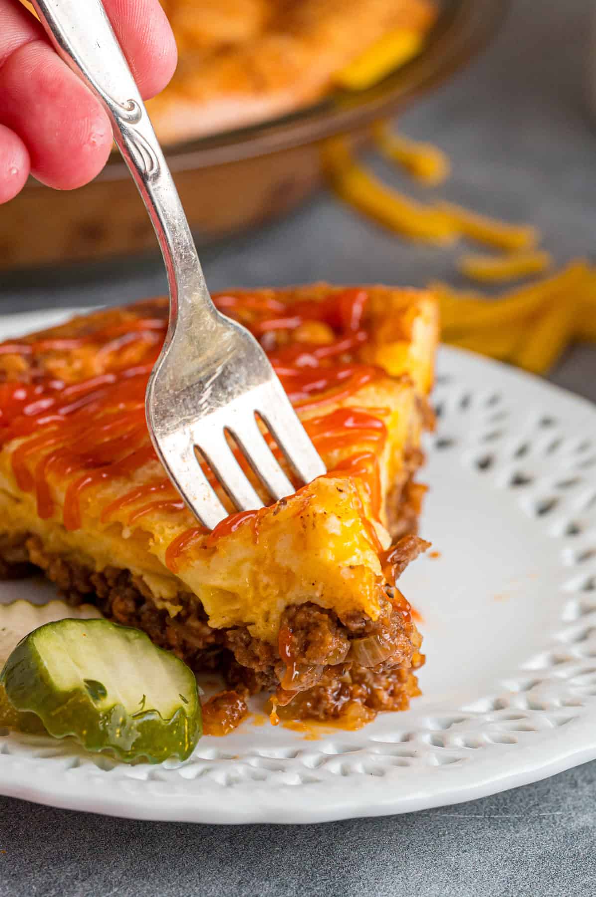 A fork in a slice cheeseburger pie