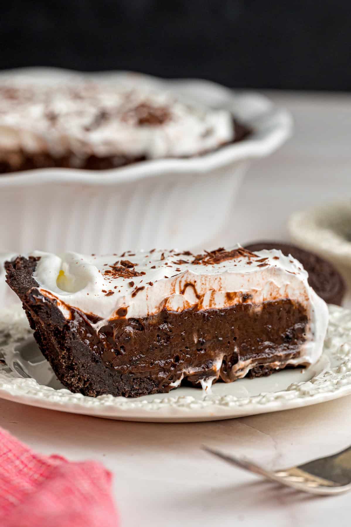 With a smooth, creamy filling in an Oreo crust, this Chocolate Pudding Pie is made in 15 minutes with 5 ingredients & 0 cooking or baking. A slice of chocolate pudding pie on a white plate