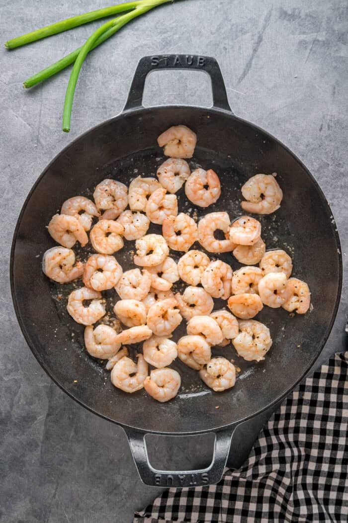 With juicy shrimp, veggies, and scrambled egg, this Shrimp Fried Rice recipe is better than takeout! Ready in just 30 minutes! Shrimp cooking in a wok