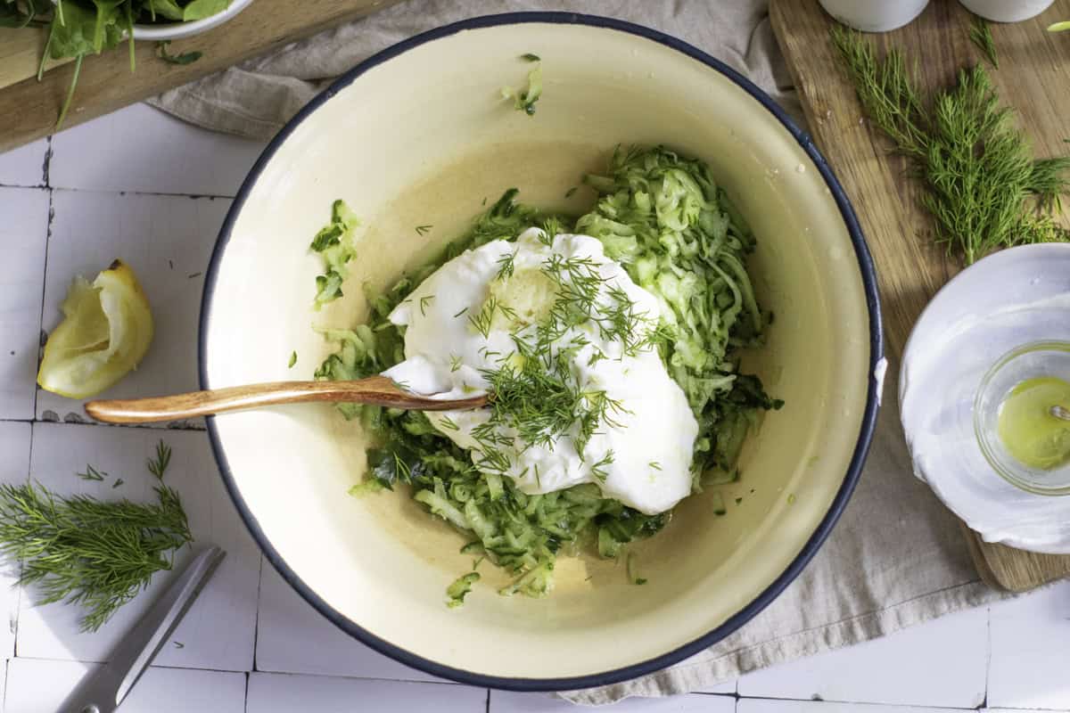 Combining tzatziki ingredients in a bowl