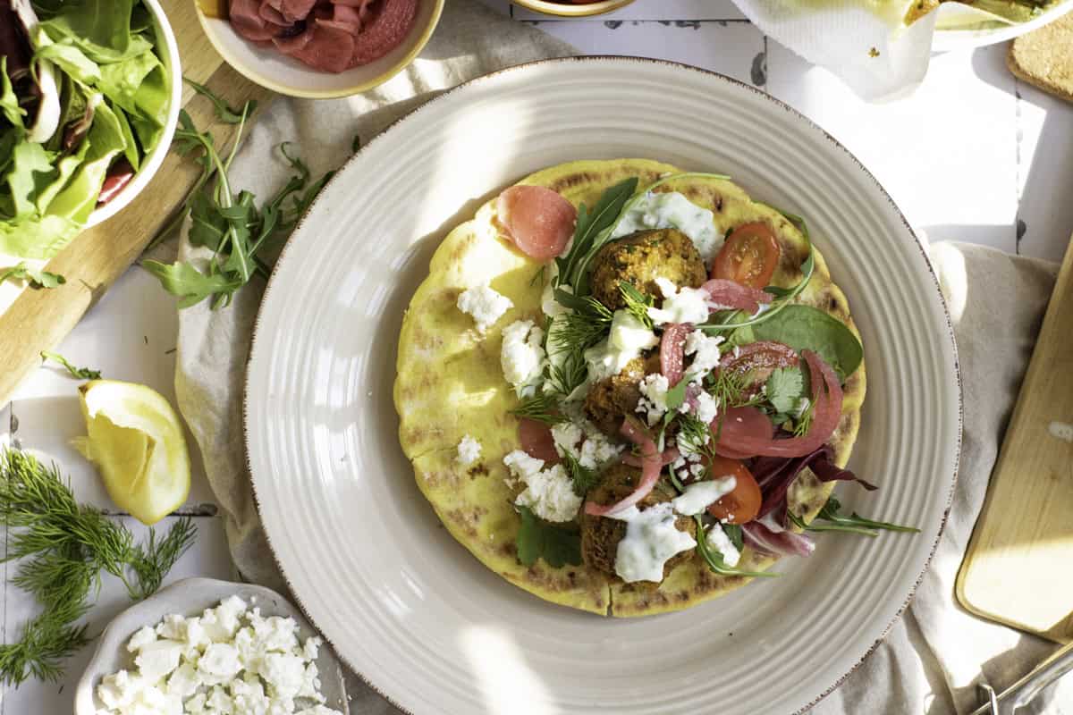 Assembling a falafel wrap on a plate