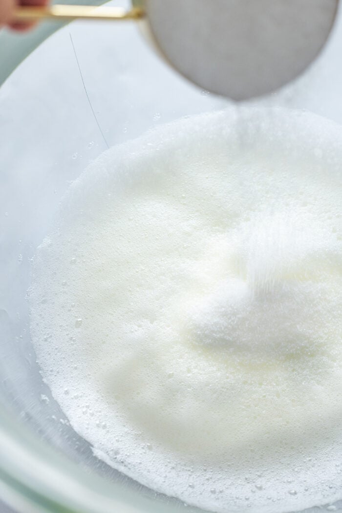 Adding sugar to frothy egg whites