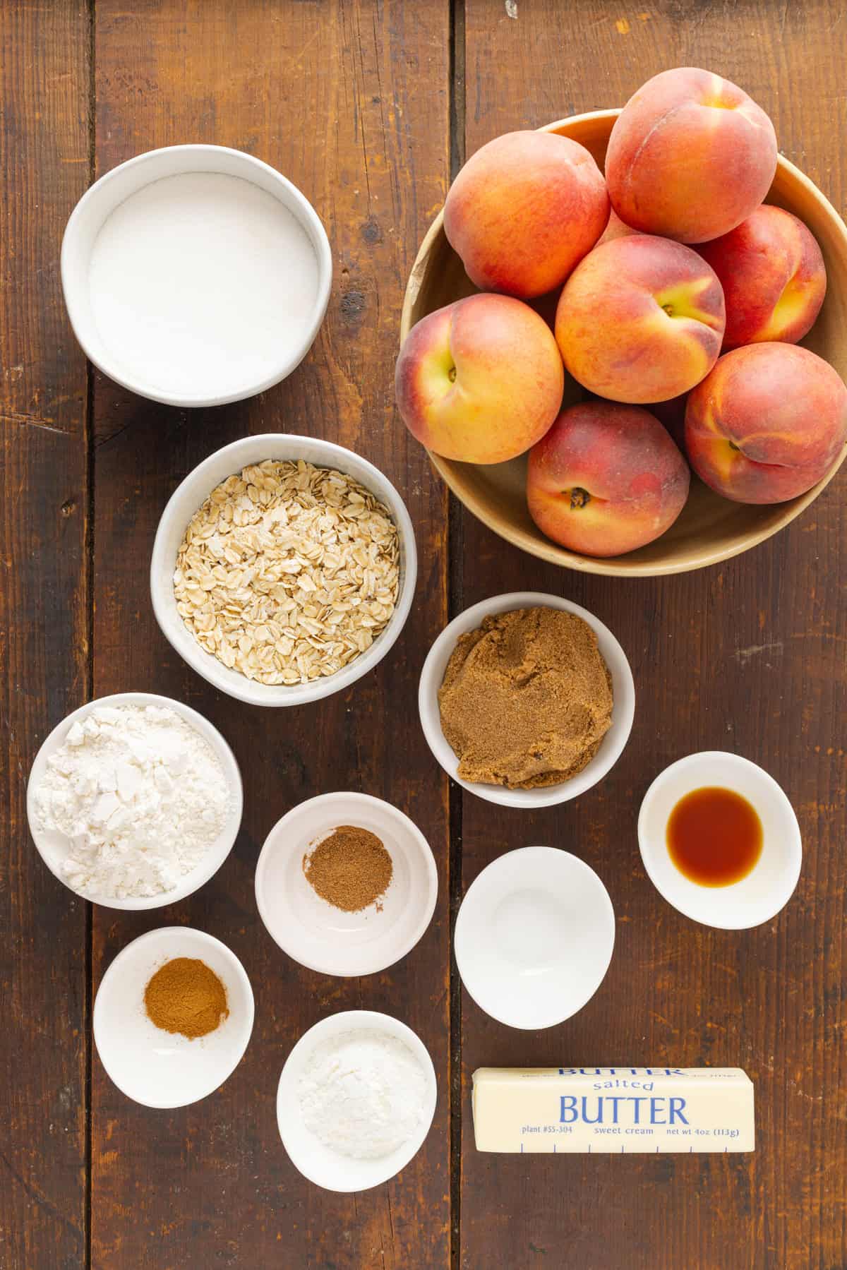 Warmly spiced fresh peaches are topped with a crumble topping in this Peach Crisp recipe. Serve with ice cream for a quick & easy dessert! Overhead view of ingredients needed to make peach crisp