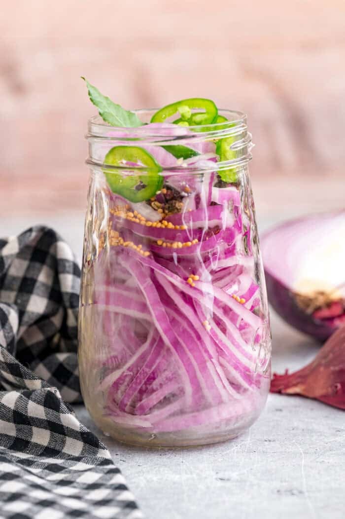 Sliced red onions and jalapenos in a jar