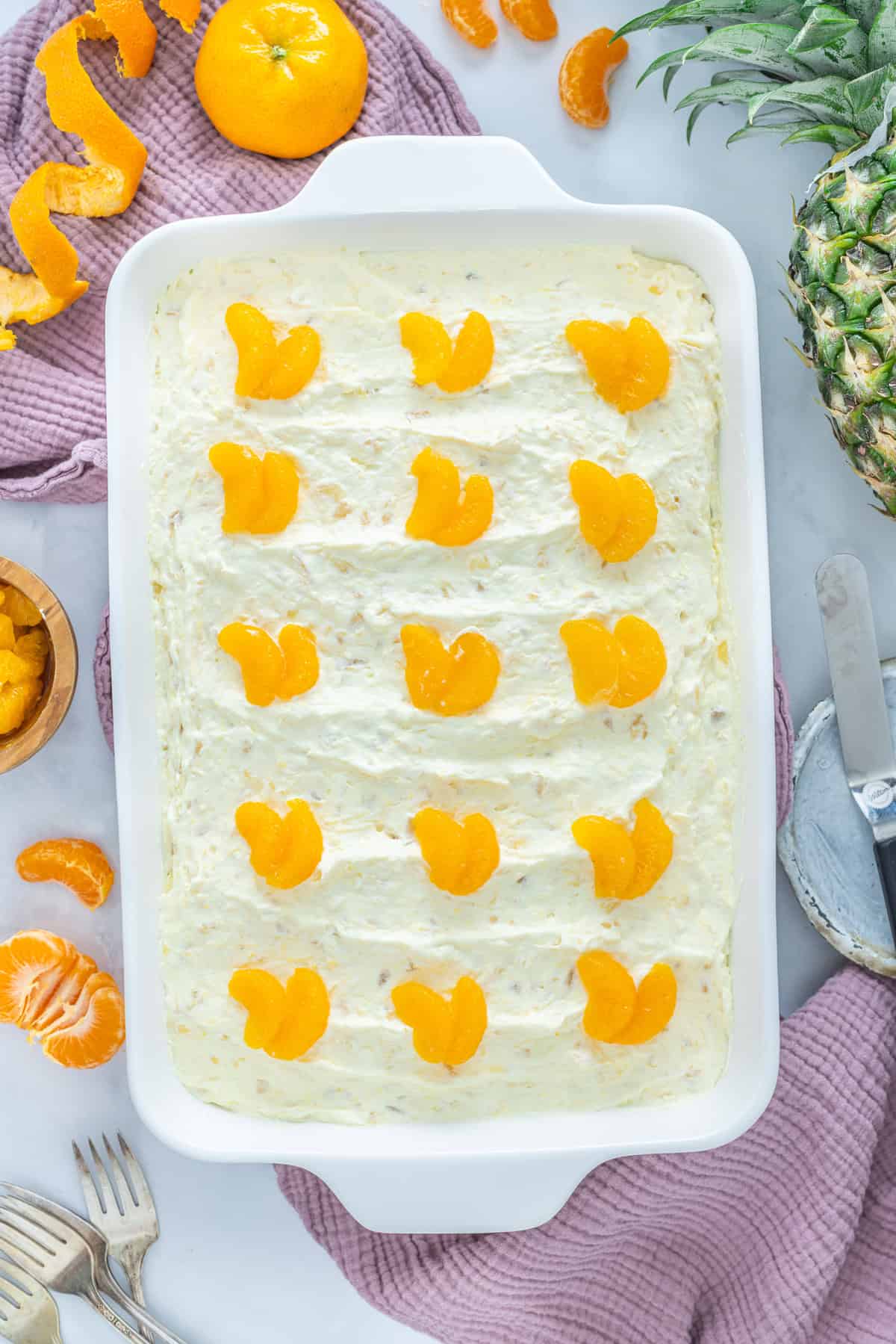 This Pig Pickin' Cake is made with box cake mix combined with mandarin oranges and a pineapple Cool Whip frosting. SO easy to make! Overhead view of pig pickin' cake