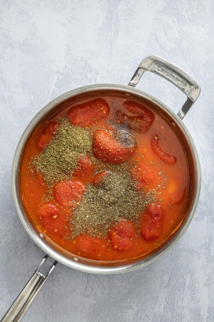 Spices added to roma tomatoes in a pan