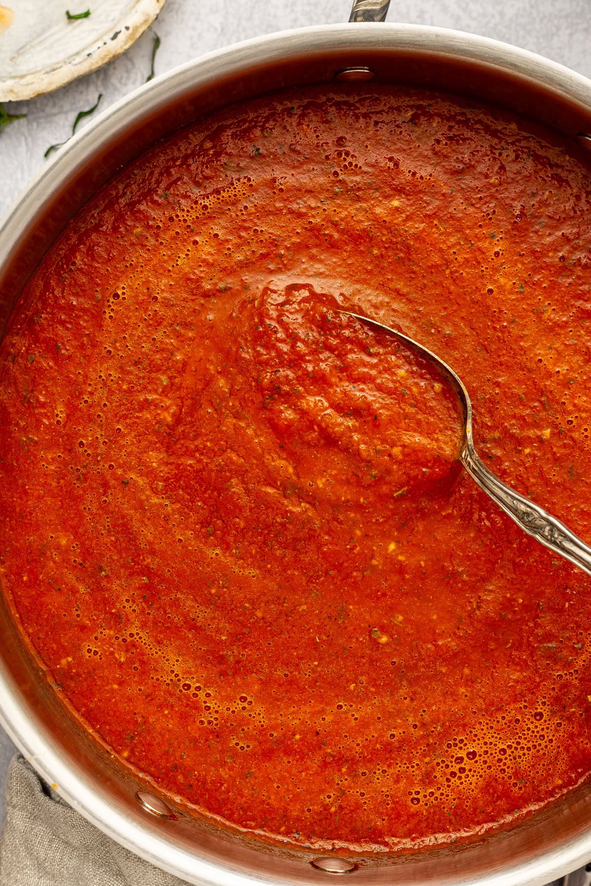A spoon stirring pomodoro sauce