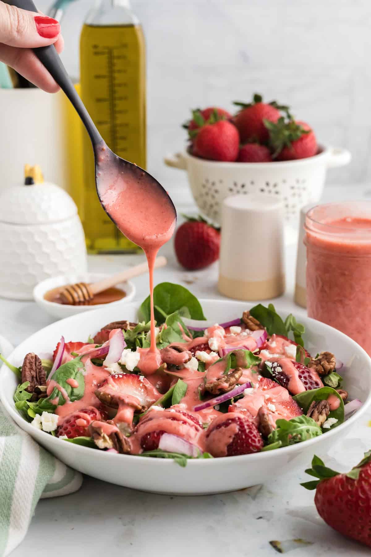Drizzling strawberry vinaigrette over a salad
