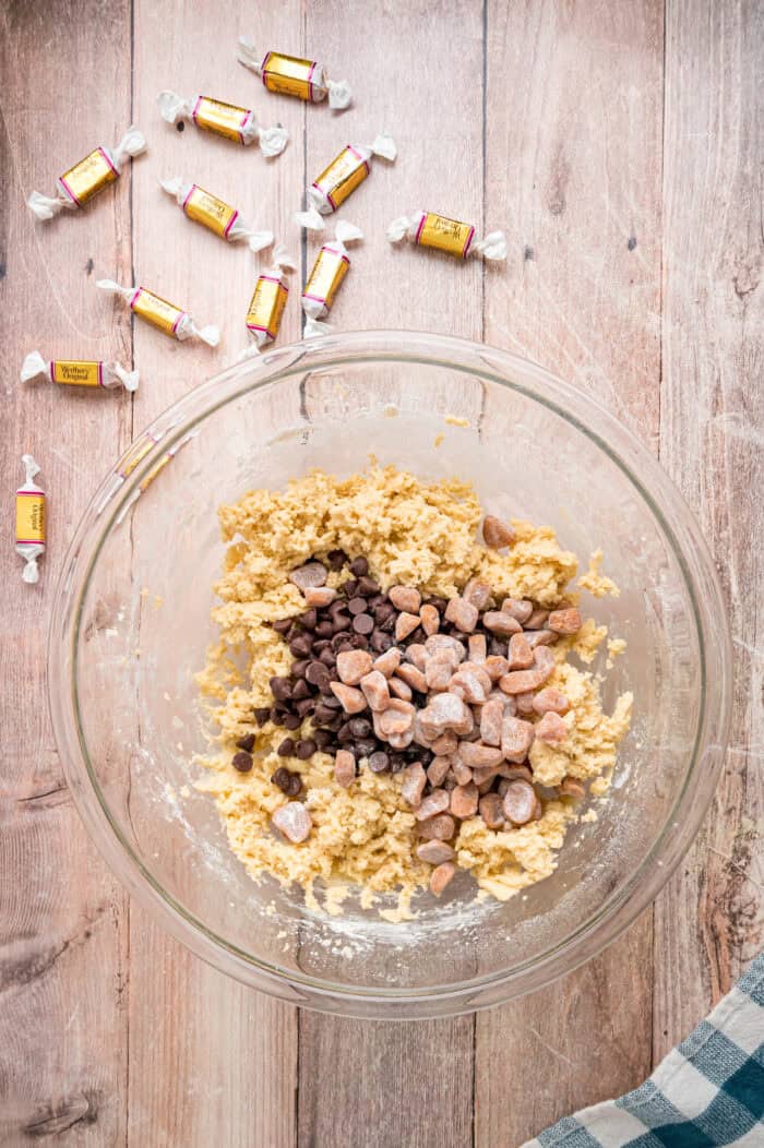 Chocolate chips and caramel pieces added to cookie dough