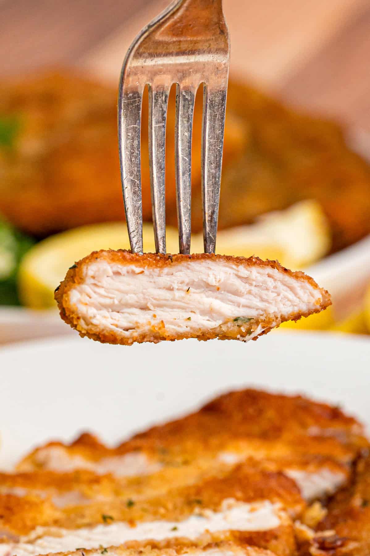 A piece of chicken milanese on a fork