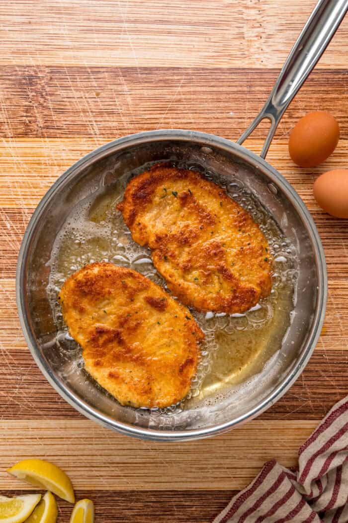 Chicken milanese frying in a pan