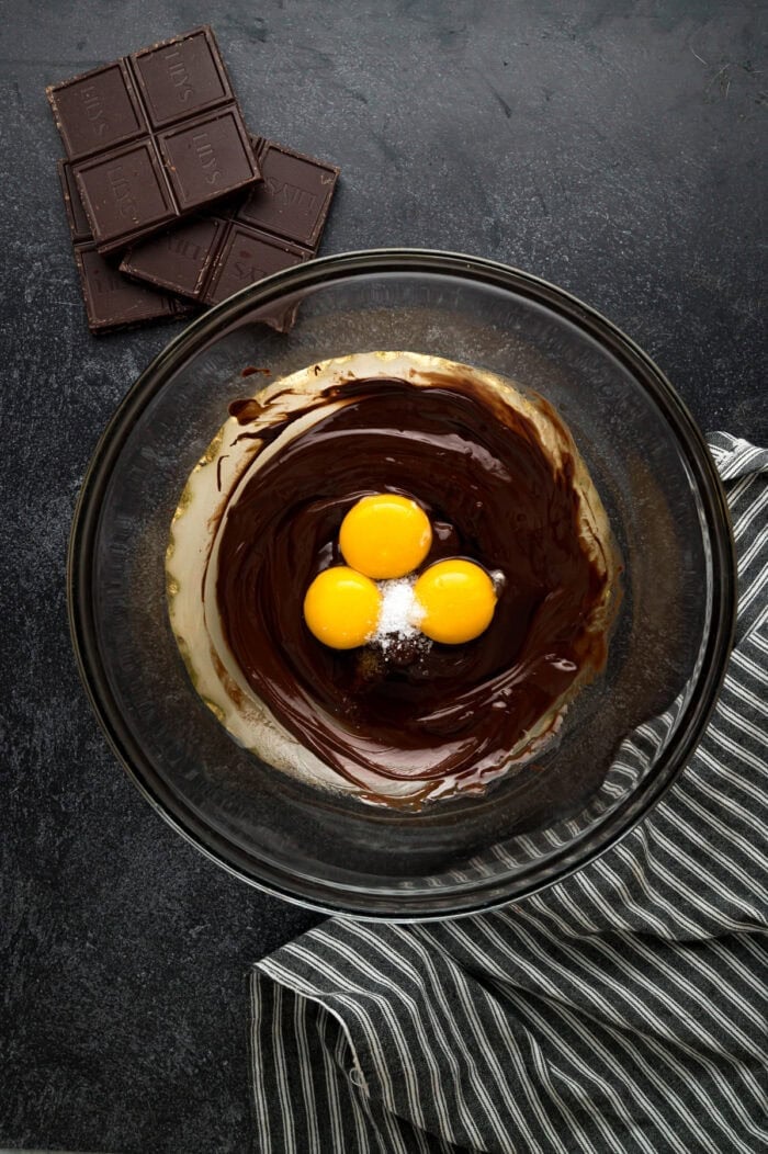 Egg yolks added to a bowl of melted chocolate