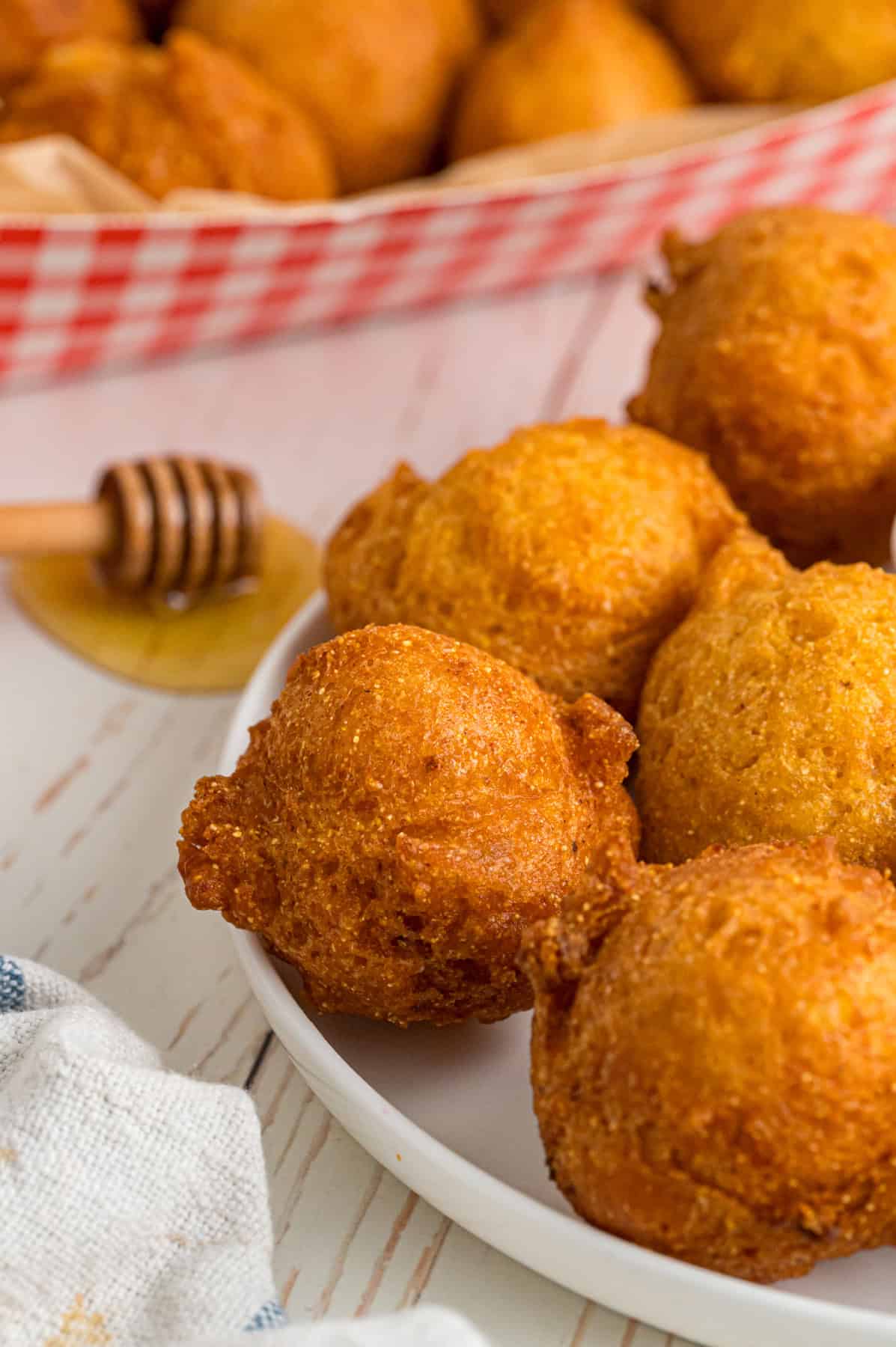 A plate of hush puppies with honey