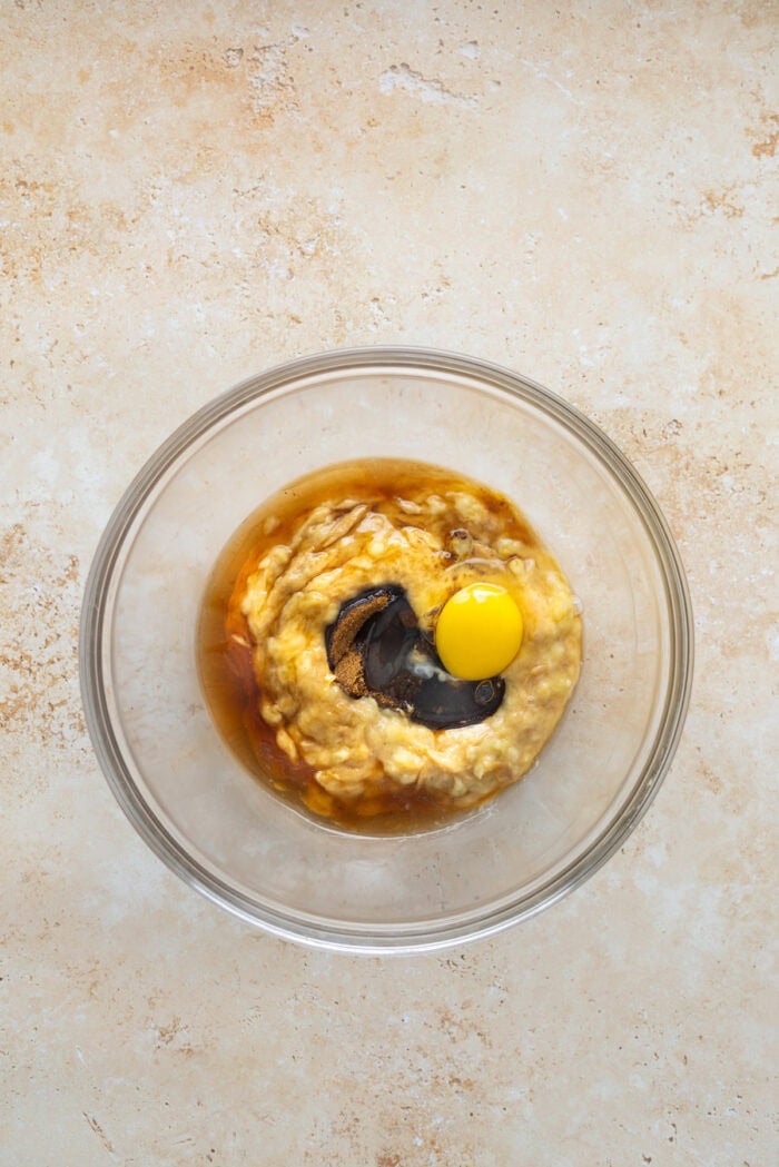 Adding egg and vanilla to mashed bananas