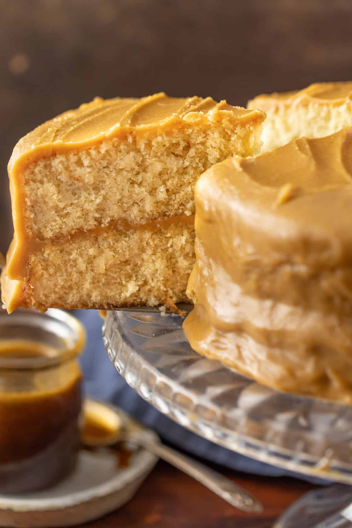 A spatula removing a slice of caramel cake