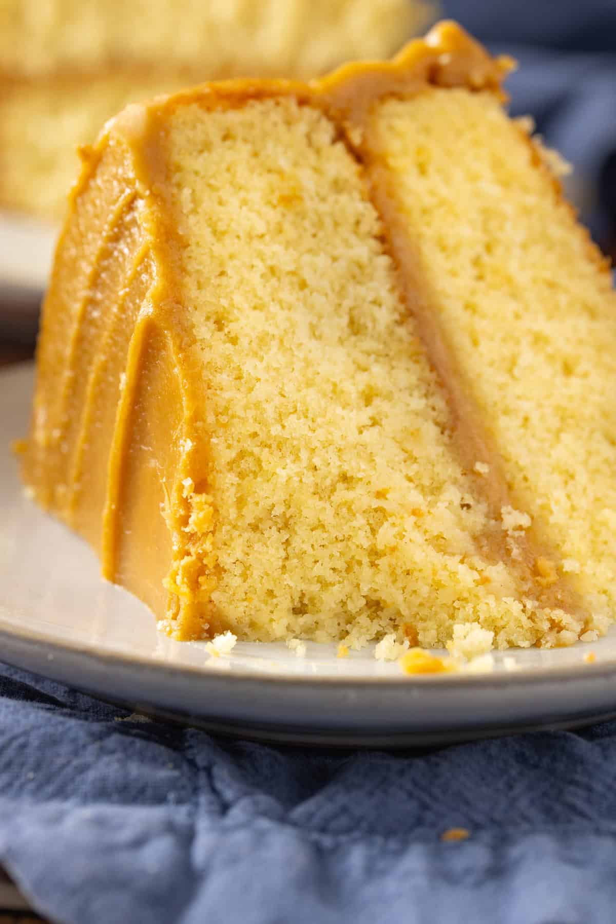 A slice of caramel cake on a white plate