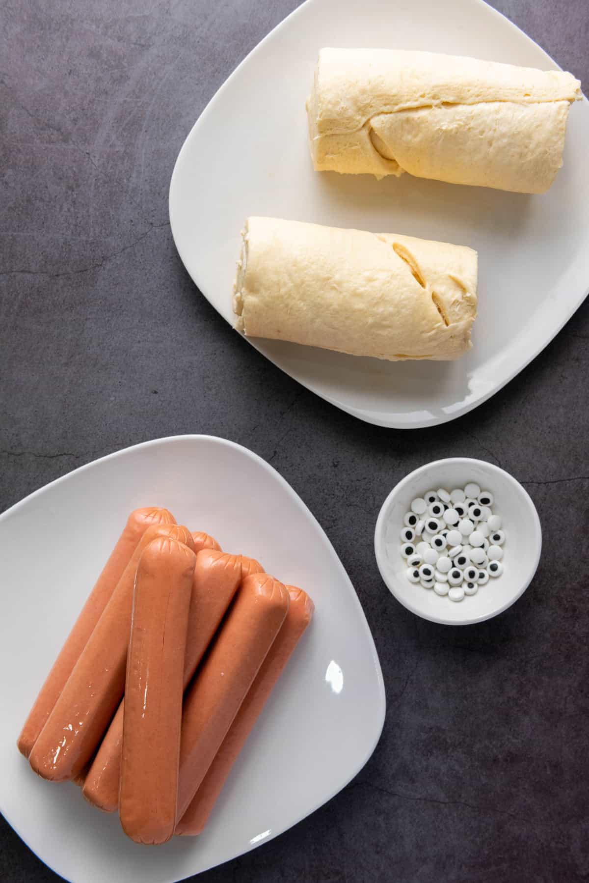 Hot dogs, crescent roll dough, and edible eye balls.