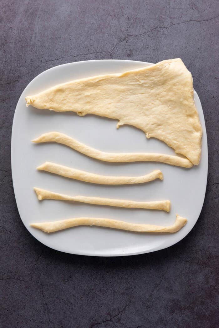 A crescent roll triangle cut into strips on a plate