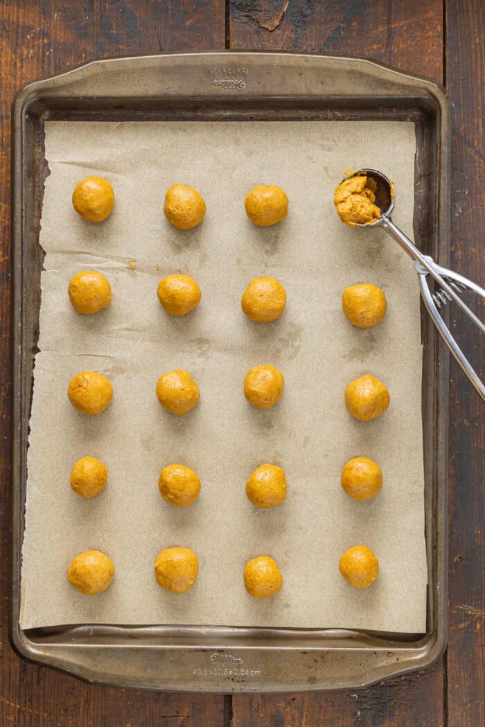 Small balls of pumpkin truffles on a baking sheet